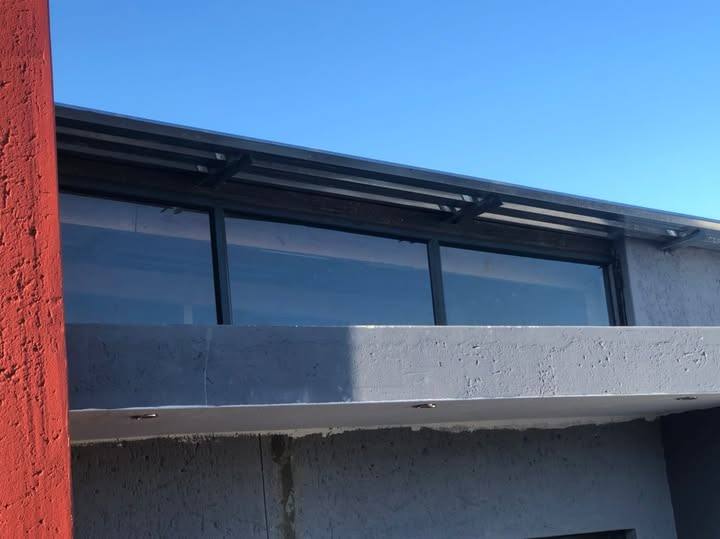 Row of aluminium windows along a rooftop extension