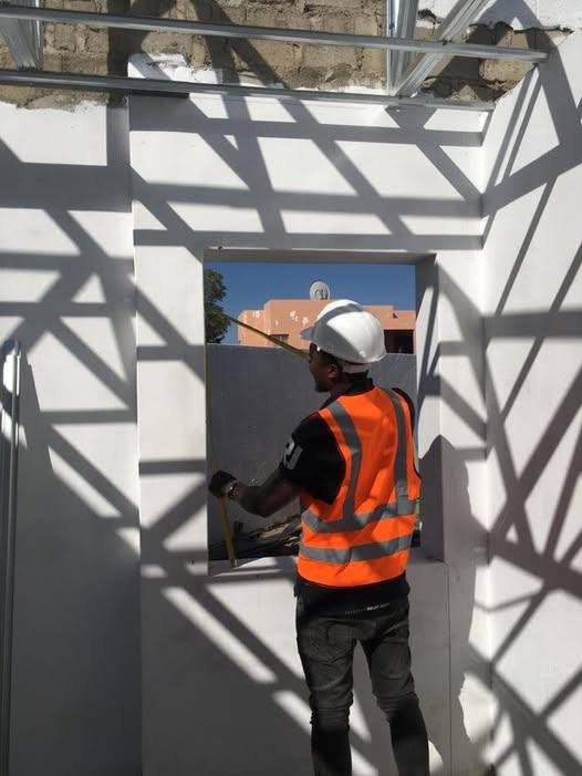 M.A.N installer fitting an aluminium window frame on site